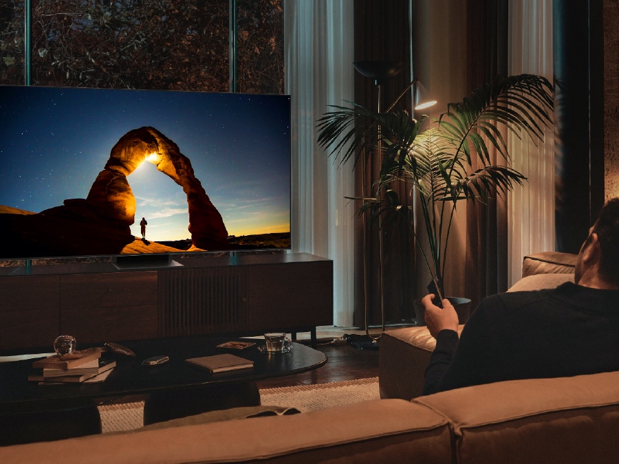 A man is watching his QLED TV at night with the screen optimally adjusted in EyeComfort mode.