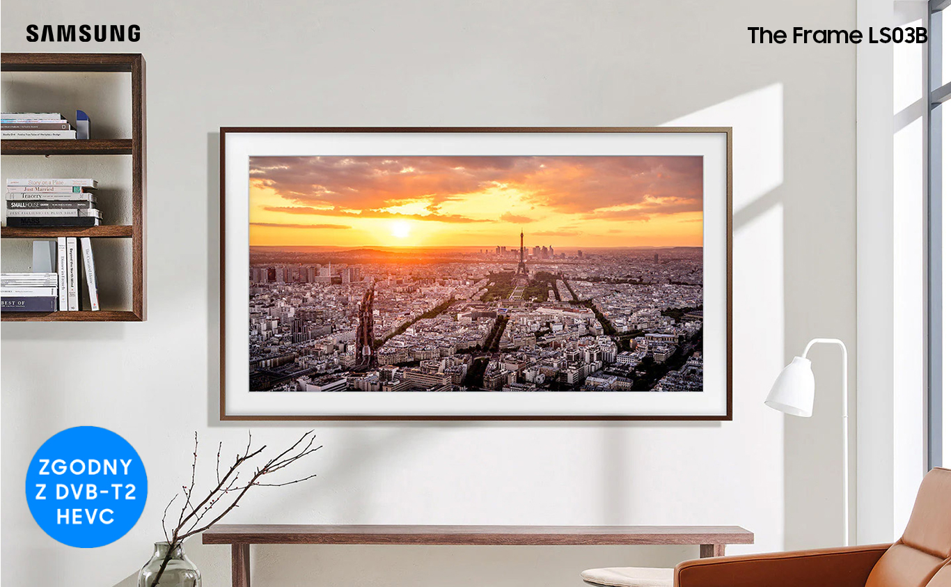 The Frame is hanging on a wall in a living room displaying a sunset over a city. LS03BBUXXH